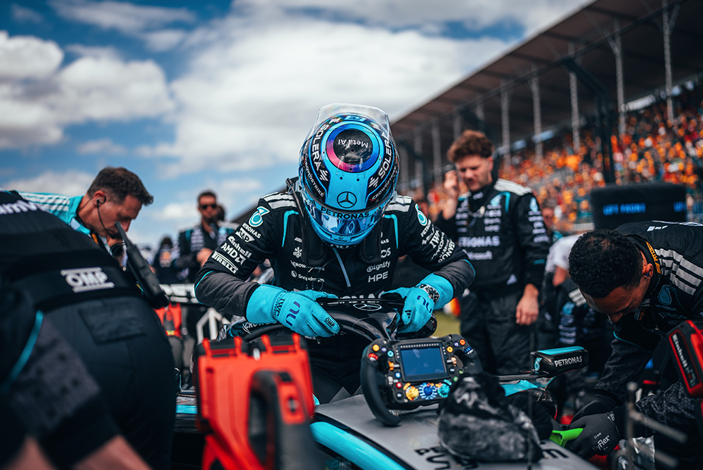Mécaniciens de Formule 1 travaillant sur une voiture de course dans la voie des stands.